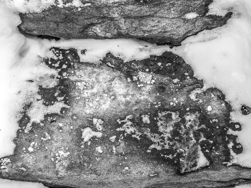 black and white, closeup of stone steps with salt and snow